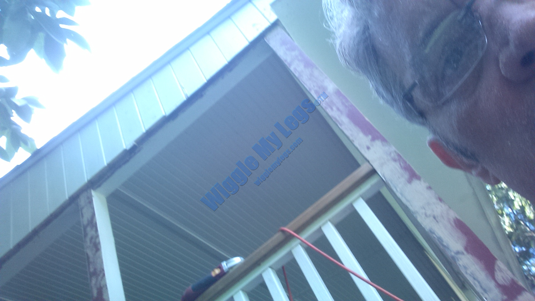 Same corner post upward view showing shiplap wood siding on gable.