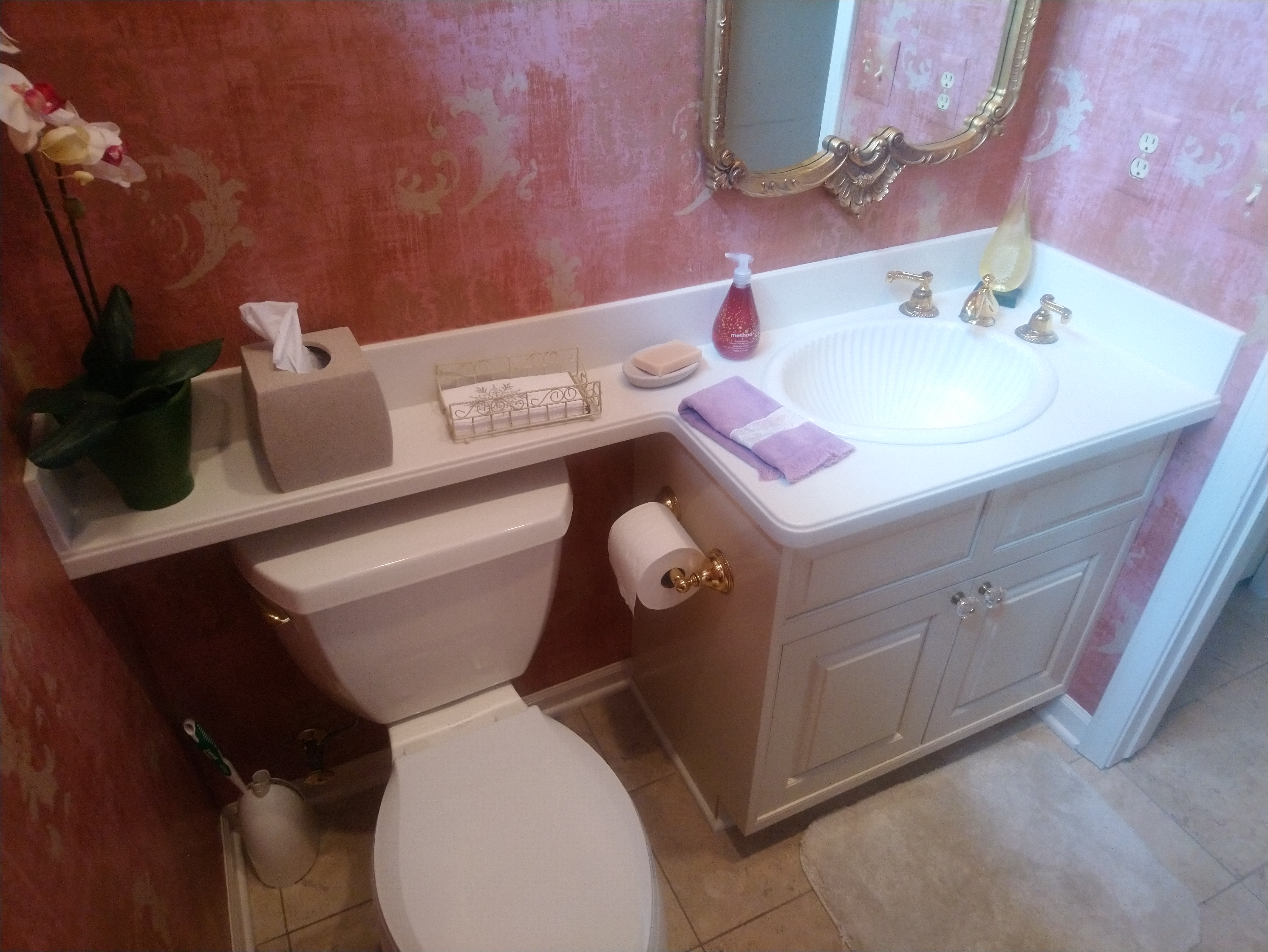 Before photo of the same style half bath showing wall to wall countertop.