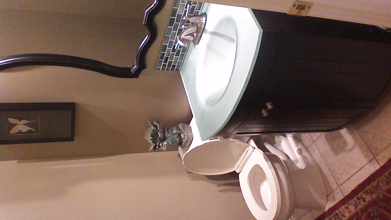 View of remodeled half bath standing on threshold looking at sink and mirror.