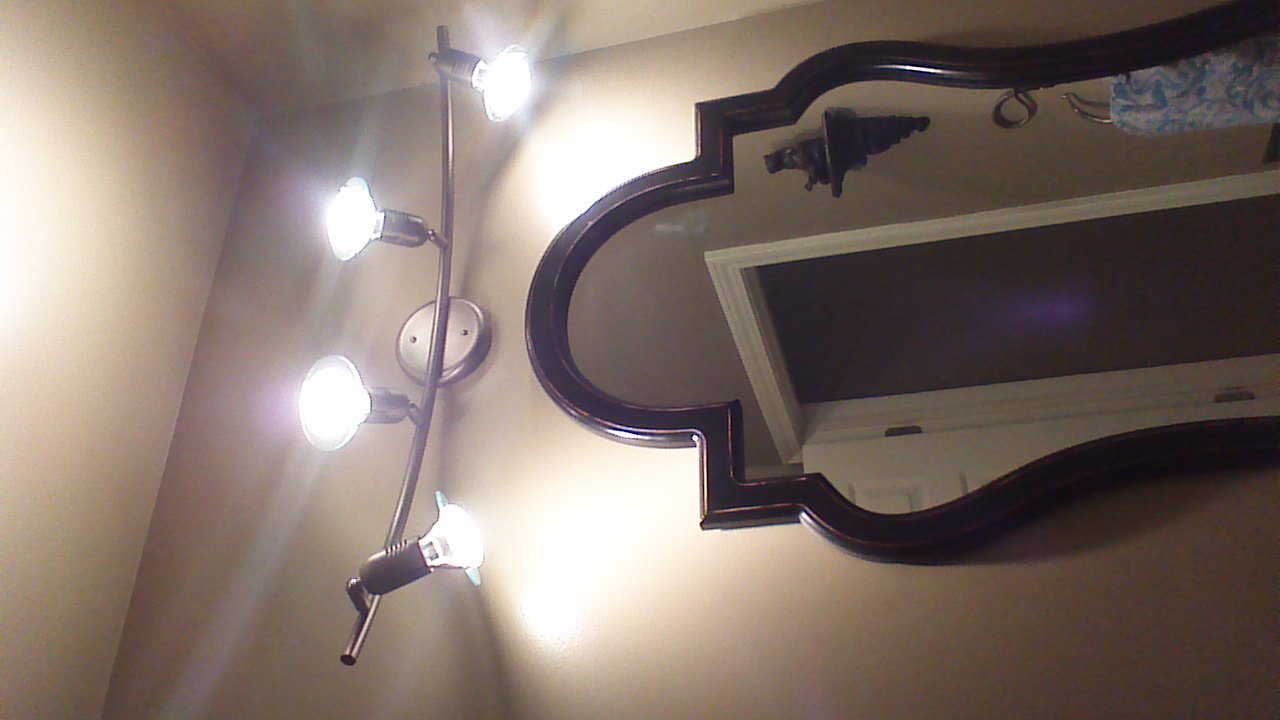 Photo of upward view to new light fixture above mirror.